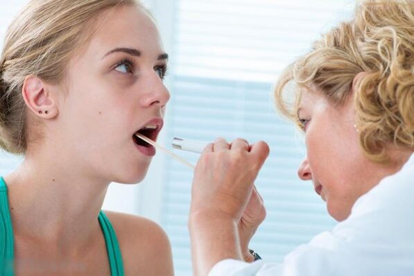 Лекарят изследва устната кухина за наличие на папиломи